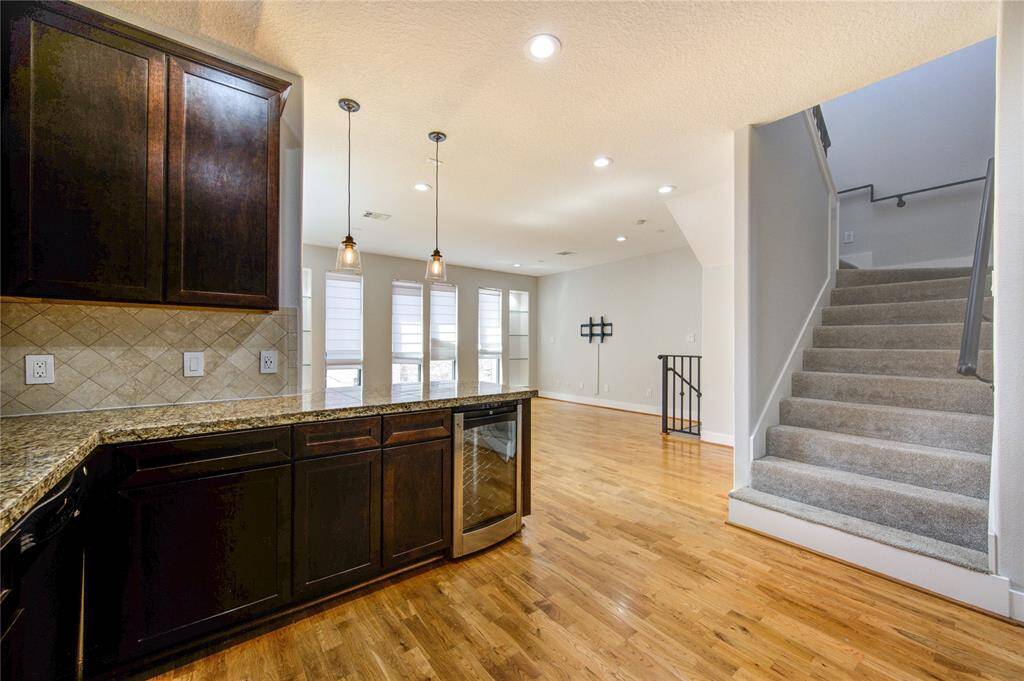 A stylish tile backsplash adds a touch of sophistication, while the open-concept layout seamlessly connects the kitchen to the dining and living areas, making it perfect for entertaining.