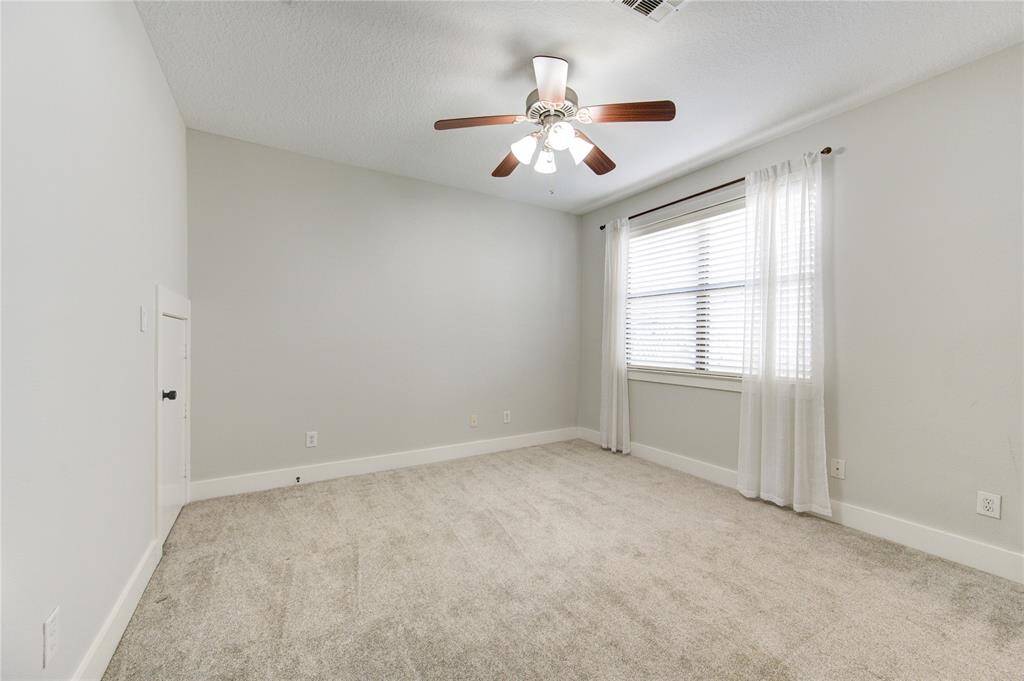 his spacious first-floor bedroom offers comfort and versatility, featuring plush carpeting that adds warmth underfoot. Large windows allow for plenty of natural light, creating a bright and inviting atmosphere.