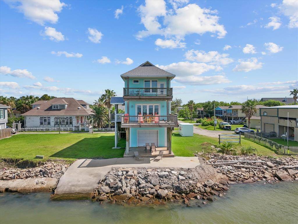 This waterfront home features a three-story design with spacious balconies, offering stunning views of the water .Perfect for enjoying serene coastal living.