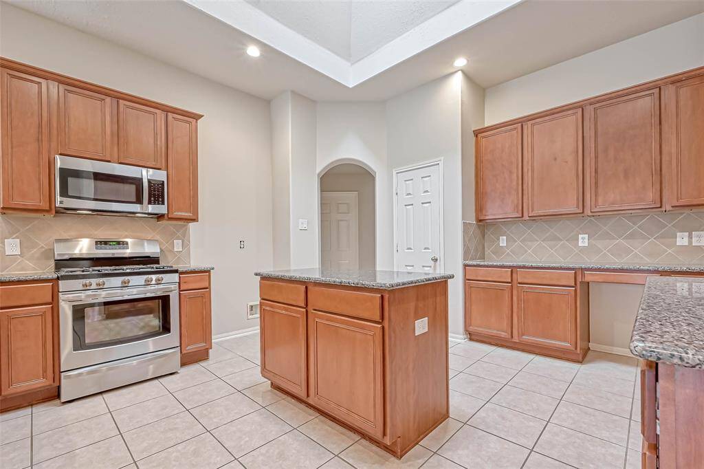 What a Kitchen with stainless appliances, granite tops 42-inch wall cabinets and a kitchen island.