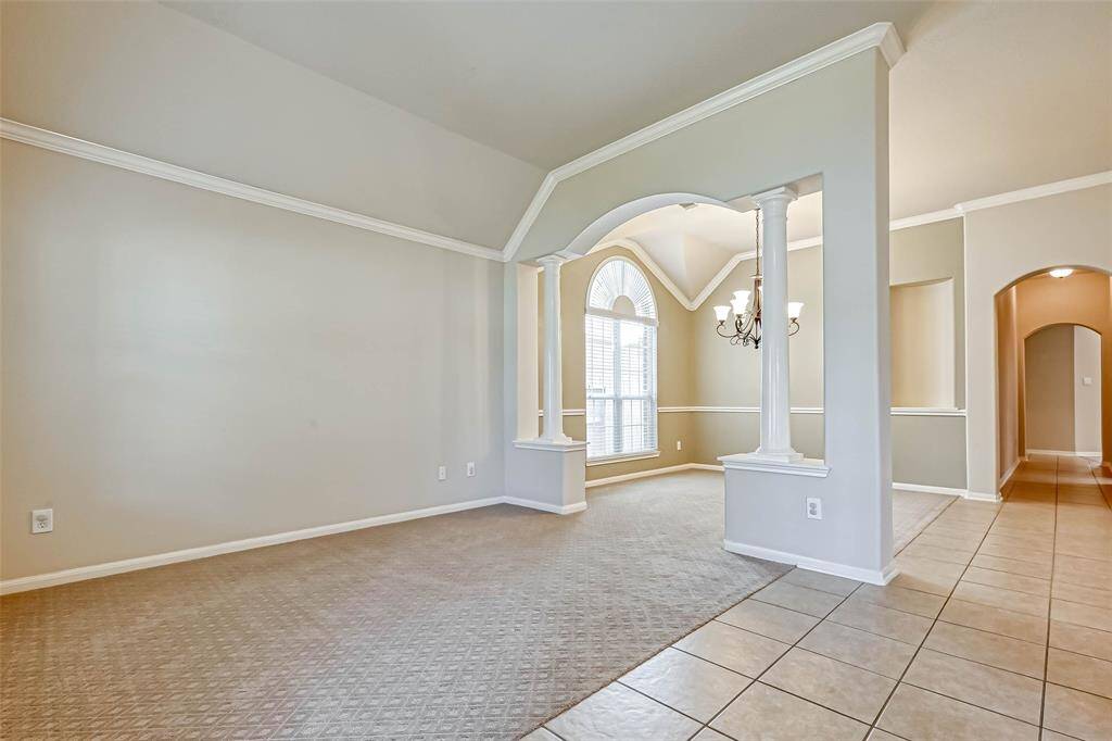 Living Room is separated from Dining Room by arched opening with a column on each side. Entry is tiled.