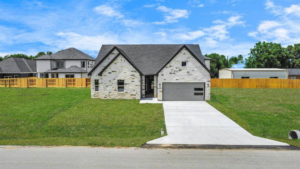 Welcome home! Modern curb appeal shines with a bold gabled roofline, full stone facade, and a private, welcoming entrance through a solid wood door.