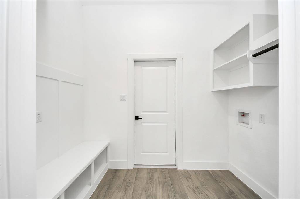 This custom laundry + mudroom combo is built for busy lives, featuring open shelving, bench seating, and garage access.