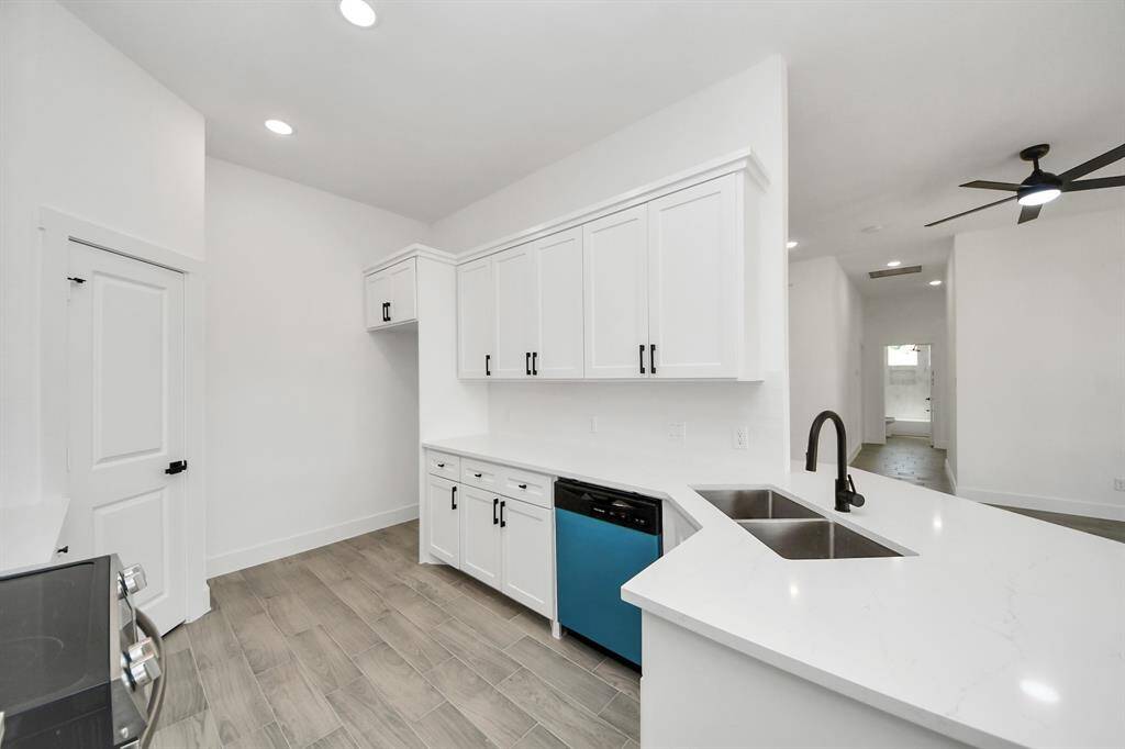 This kitchen hits every mark with quartz countertops, matte black fixtures, stainless steel appliances, and custom, solid wood cabinetry!