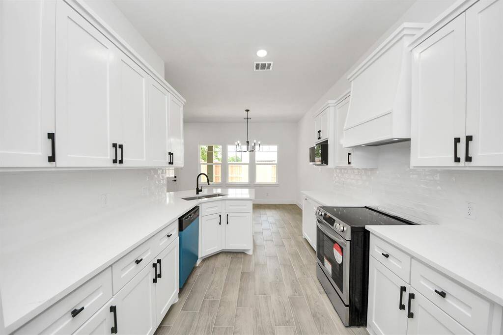 Take a look at the gorgeous custom vent hood and the upgraded stainless steel electric stove!
