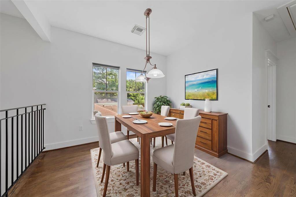 Virtually Staged: Stunning dining area featuring pendant lighting, hardwood floors, and large windows.