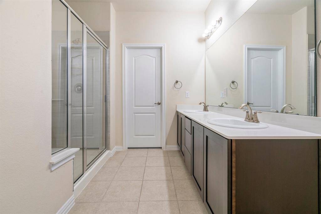 Bright, spacious bedroom with neutral walls, carpeted flooring, and three large windows providing ample natural light. Features a ceiling fan for comfort.