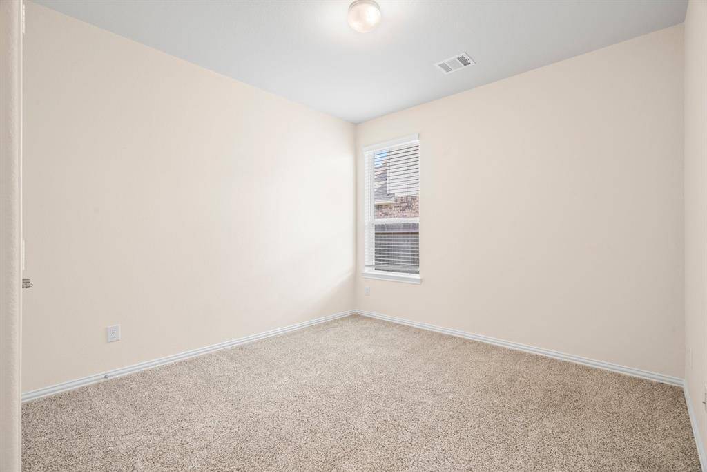 Spacious walk-in closet with ample shelving and hanging space, featuring soft carpet flooring and neutral walls for a clean, organized look.