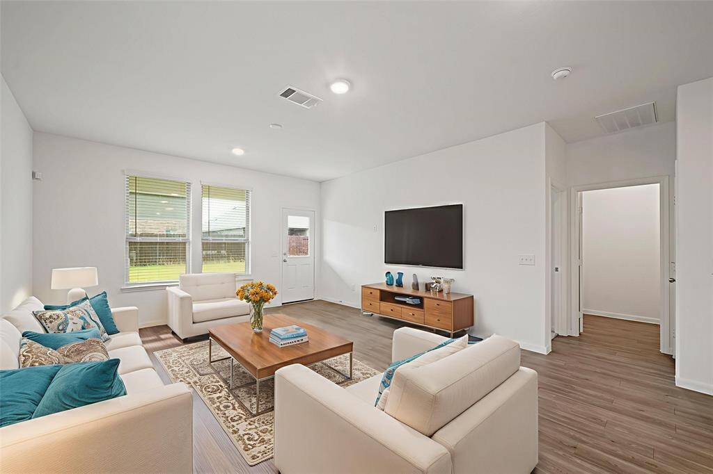 Seamless tile flooring, expansive windows, and direct access to the backyard beautifully enhance this inviting space. - virtually staged