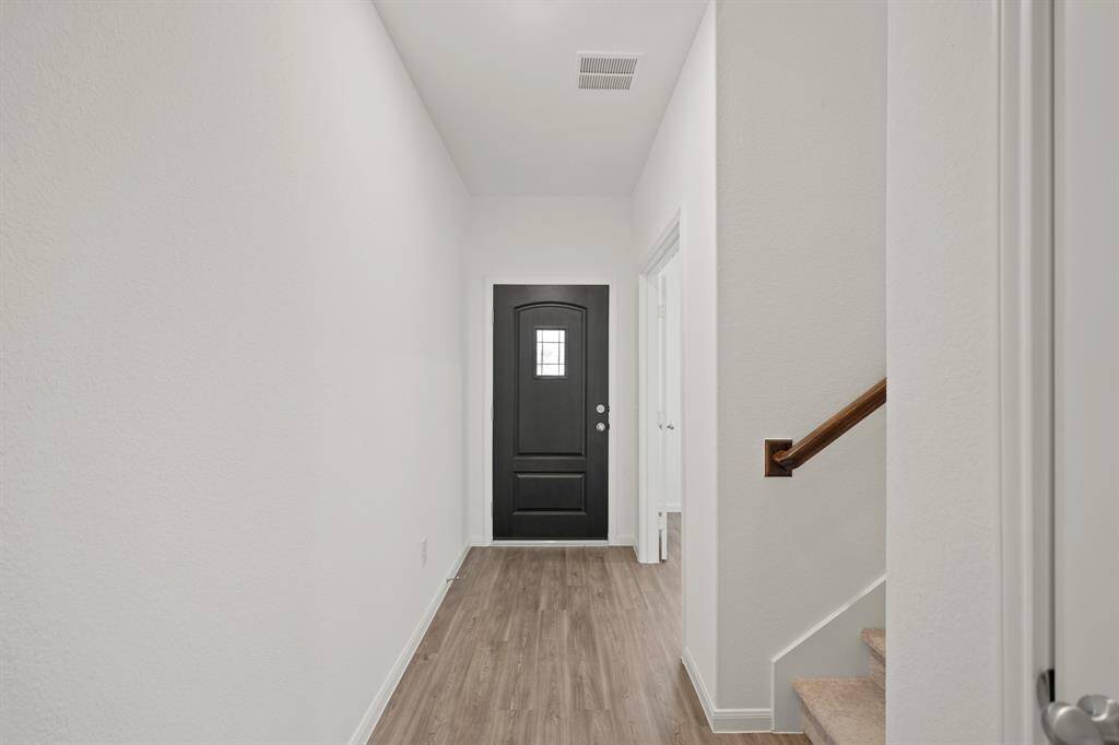 An alternate view of the gorgeous front foyer. Take a moment to admire the engineered wood flooring that adds warmth and elegance to every step.