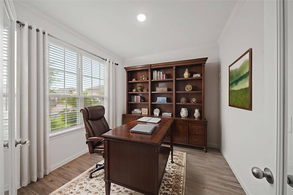 Bathed in beautiful natural light from the wall of windows, this private study is perfect for quiet productivity, creative pursuits, or simply a tranquil escape. - virtually staged