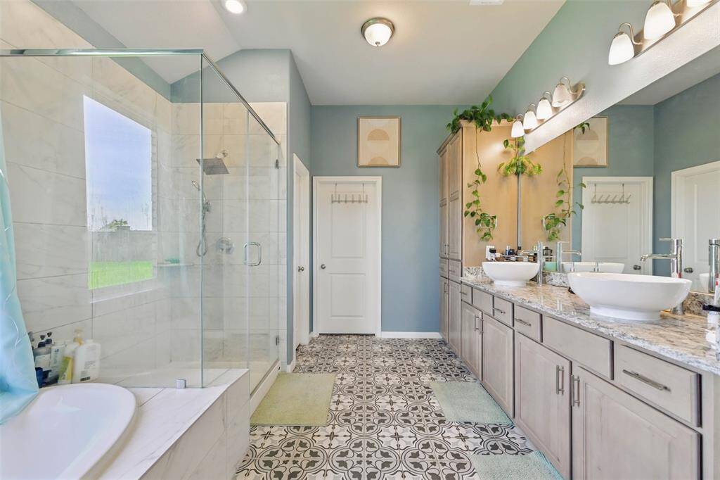 Primary bath features a walk-in shower, double sinks, soaking tub and walk-in closet