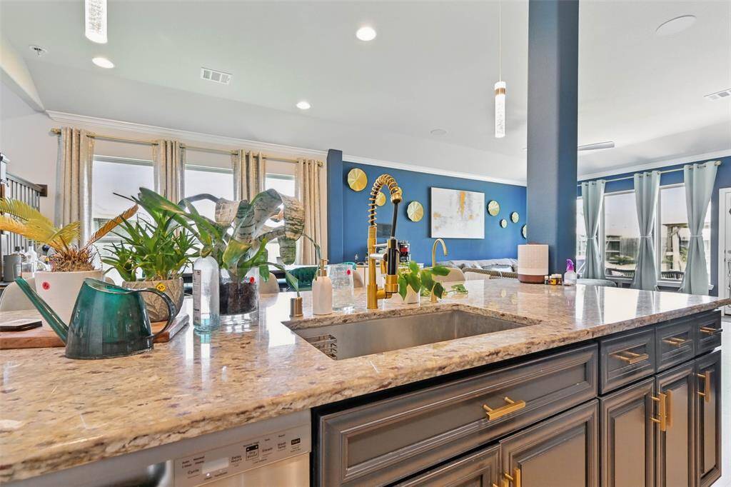 Chef's eat-in island kitchen features lengthy granite countertops, 42" cabinets with crown molding and stainless steel appliances