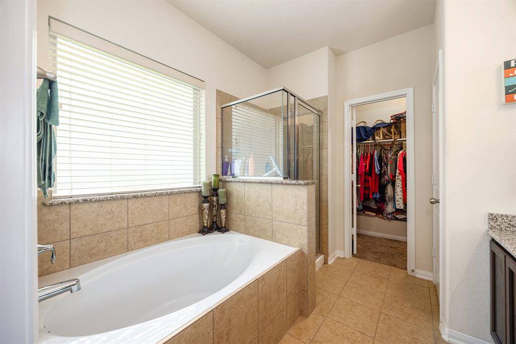 Primary soaking tub with separate walk in glass shower.