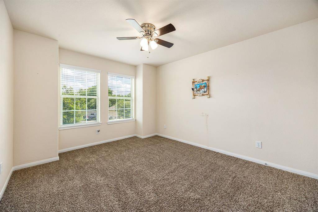 This secondary bedroom is great for use as an in-law suite or guest suite features lovely modern ceiling fan, plush carpet, space for seating area, and 2 large windows with privacy blinds!