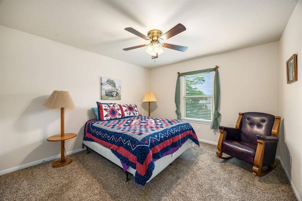 This secondary bedroom features plush carpet, modern ceiling fans and natural light