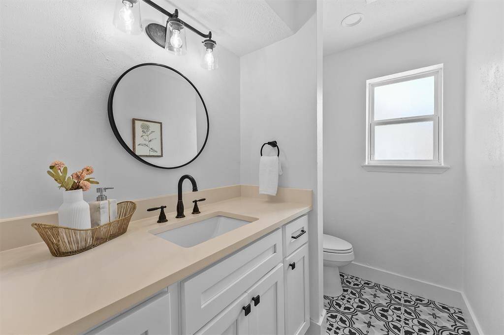 Downstairs powder bath with stylish tile and quartz countertop.