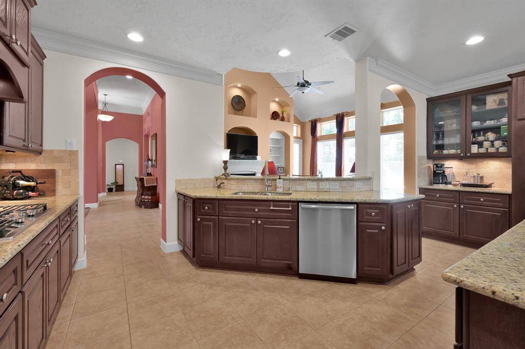 Rich Cabinets and Granite Counters Accentuate Large Island Kitchen.