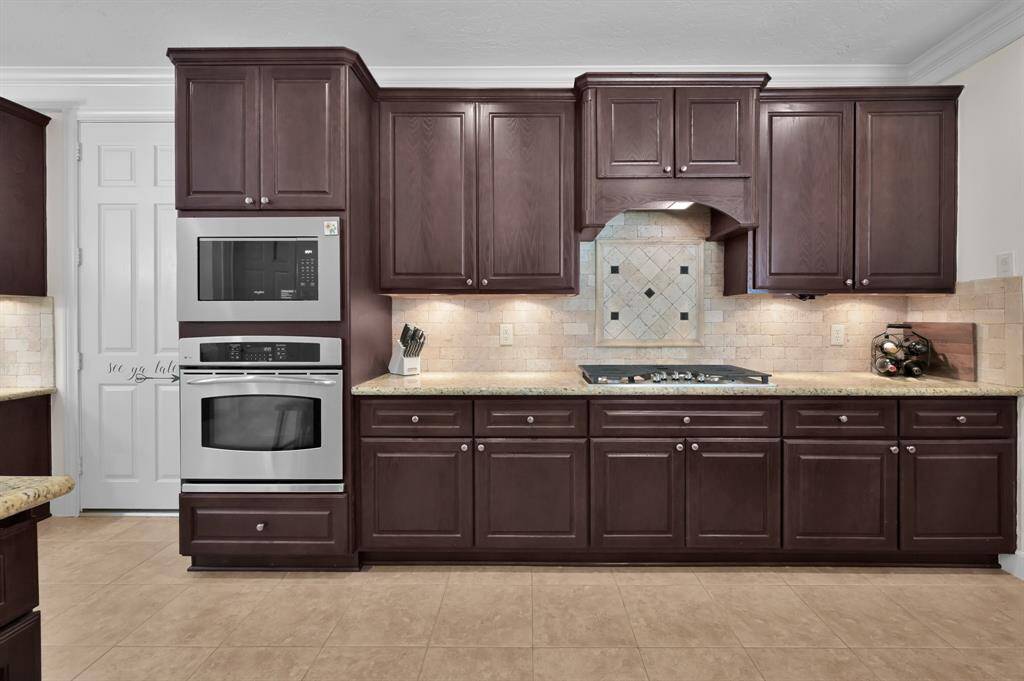 Updated Backsplash and Cooktop Perfectly Finish Out Warm Kitchen.