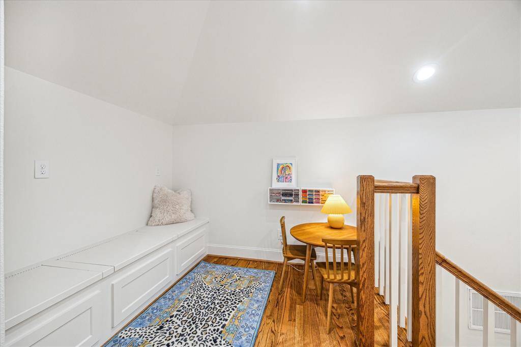 Upstairs is a quaint landing, perfect for a home office or afternoon study sessions. Built-in storage bench, too!
