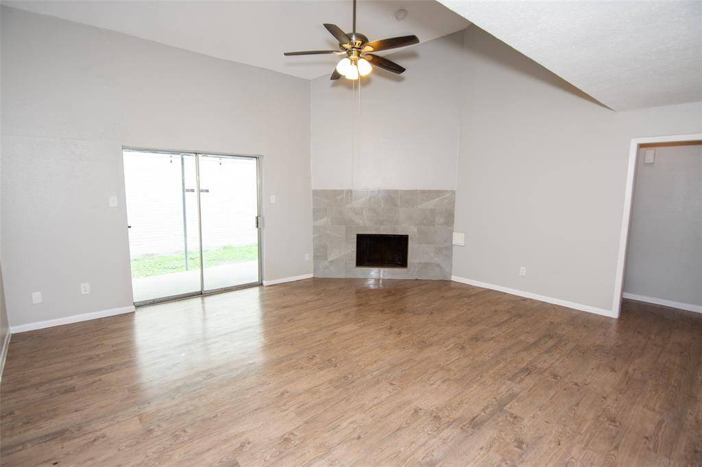 Large open Living Room with High Ceilings and Backyard Access Through the Patio Doors.