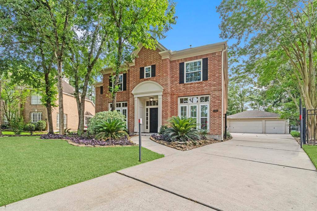 Charming two-story brick home with elegant black shutters and a welcoming arched entryway. Features a spacious driveway, detached garage, and beautifully landscaped surroundings with mature trees. Ideal for those seeking comfort and style.
