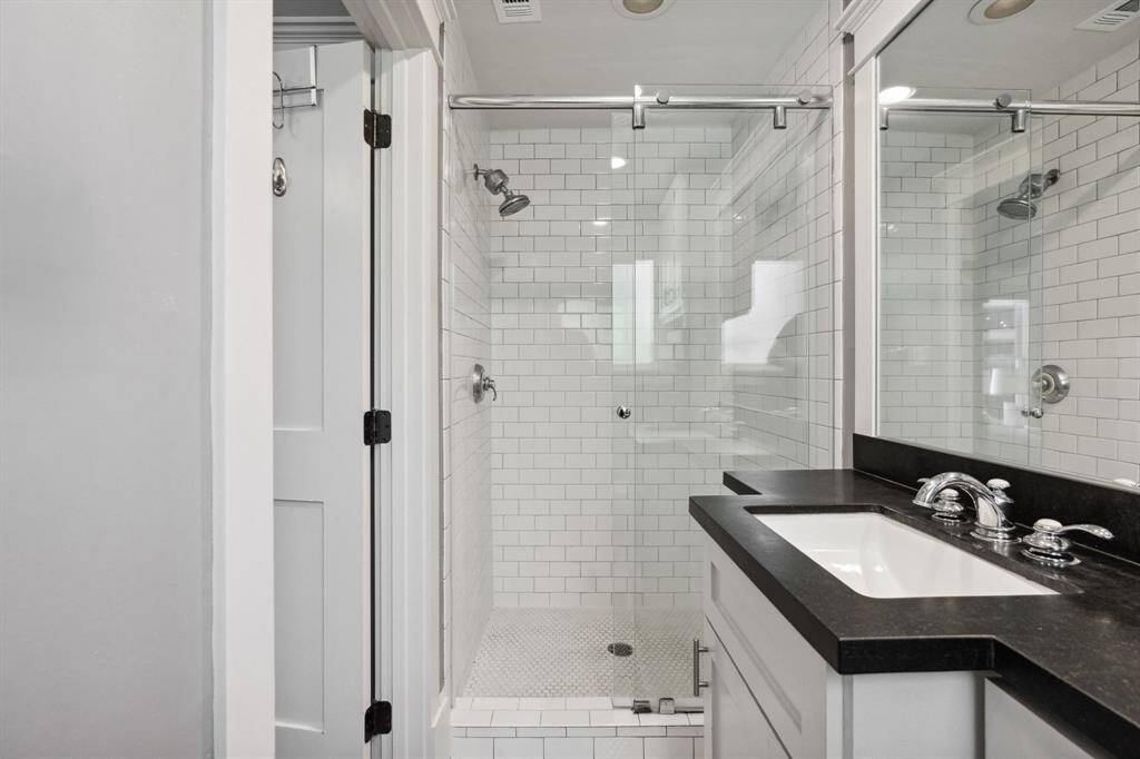Full bath en suite with glass shower, and subway tile.