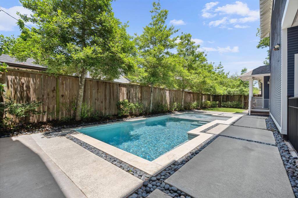 Pebble-lined detailing and sleek hardscaping frame the pool for a clean, modern finish.