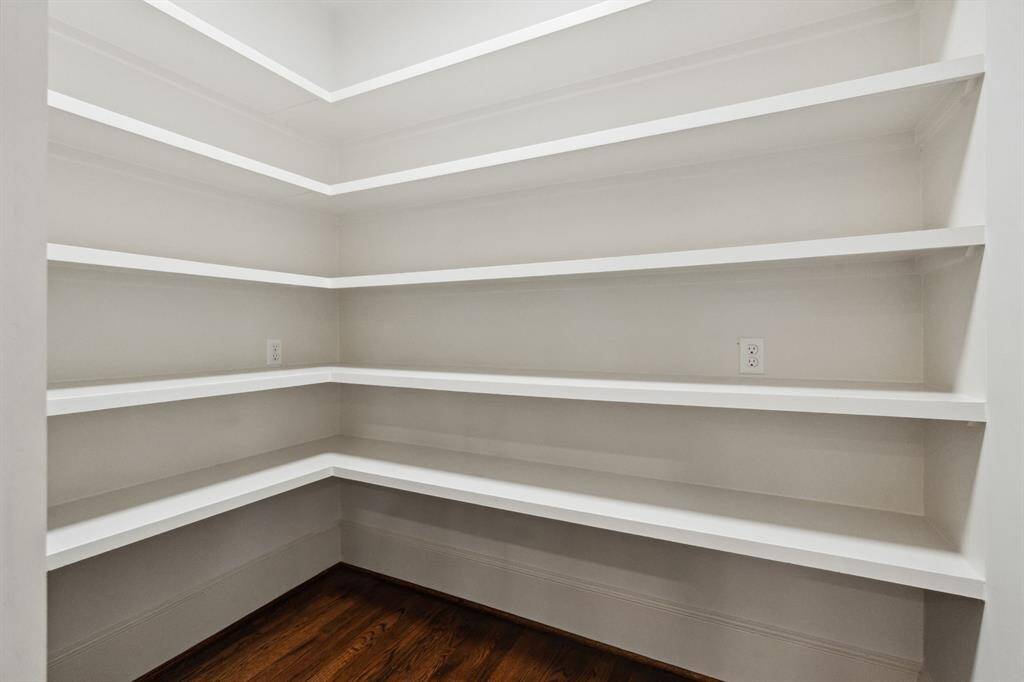 Walk-in pantry with wraparound shelving.