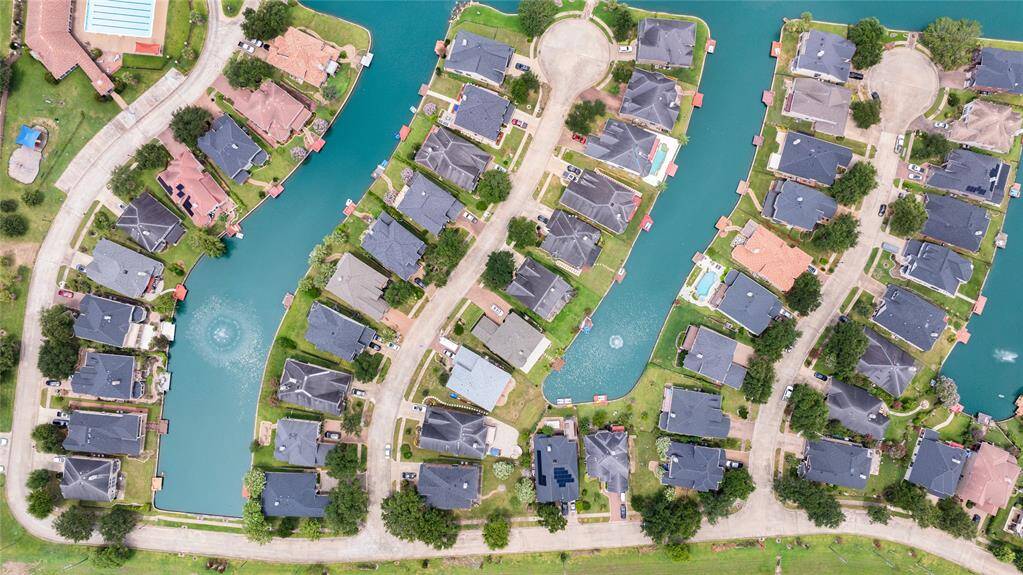 This aerial photo showcases a residential neighborhood featuring waterfront properties with direct access to a serene, man-made lake, offering a unique lakeside living experience within a suburban setting.