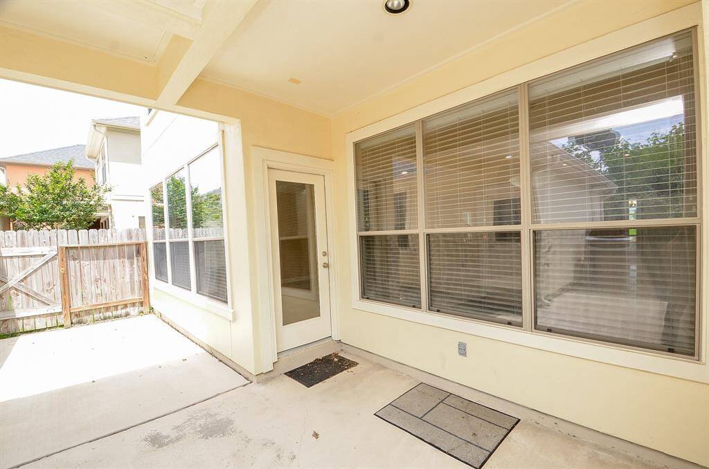 Charming covered patio perfect for relaxing or entertaining, with ample natural light and privacy.