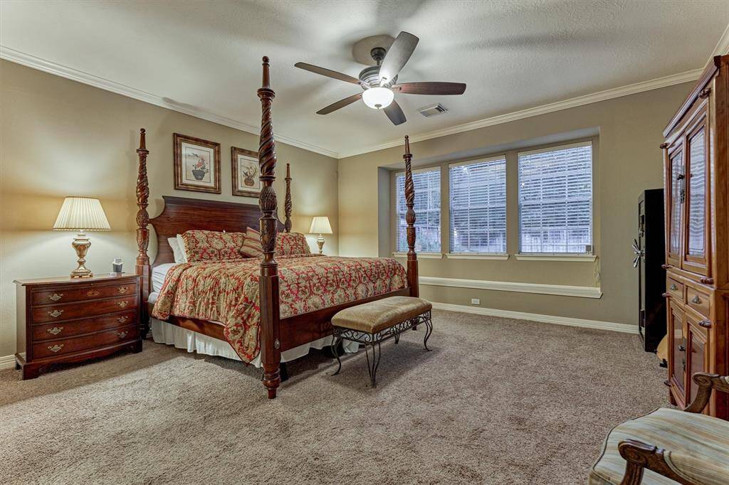 This spacious primary suite boasts large windows that provide ample natural light, and the neutral tones create a cozy atmosphere.