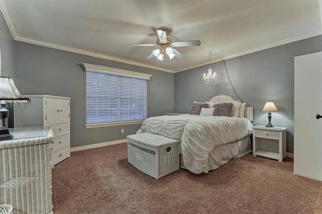 This cozy secondary bedroom features a ceiling fan with lighting while a large window provides natural light.