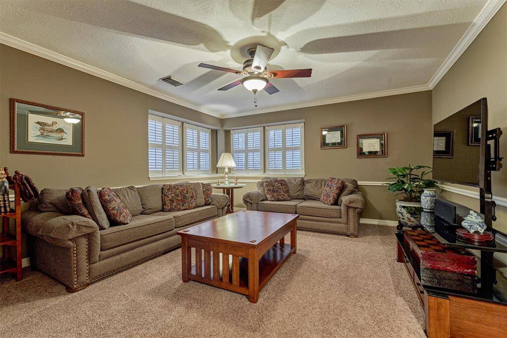 This cozy and functional gameroom features warm tones, generous space, and a ceiling fan.  The corner windows provide ample natural light.  The french doors leading into this room lends to privacy and is perfect for relaxation and entertainment.