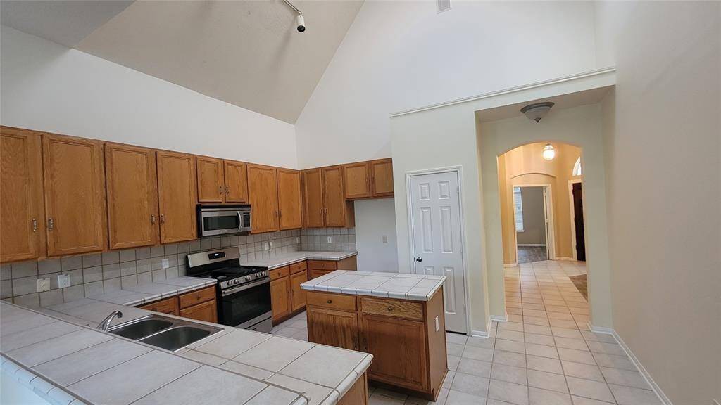 Functional and open kitchen equipped with ample cabinet storage, laminate countertops, and a full appliance suite. The layout flows effortlessly into the dining area, creating a comfortable space for daily meals or entertaining.