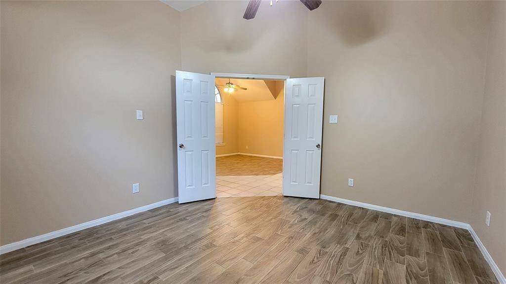 The en-suite bathroom includes a vanity with storage, a full-size mirror, and a shower/tub combination—offering both functionality and convenience.