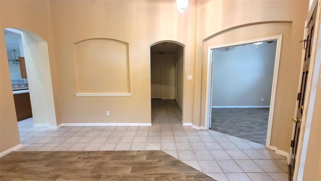 Bright and airy living space featuring neutral tones, tile flooring, and large windows that let in natural light. A cozy layout ideal for family gatherings or quiet evenings.