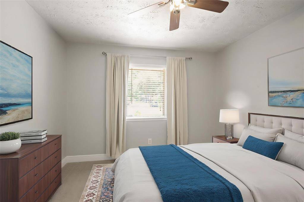 Virtually Staged: This lovely secondary bedroom features plush carpet, a ceiling fan, a large window with privacy blinds, and a Walk-In closet.