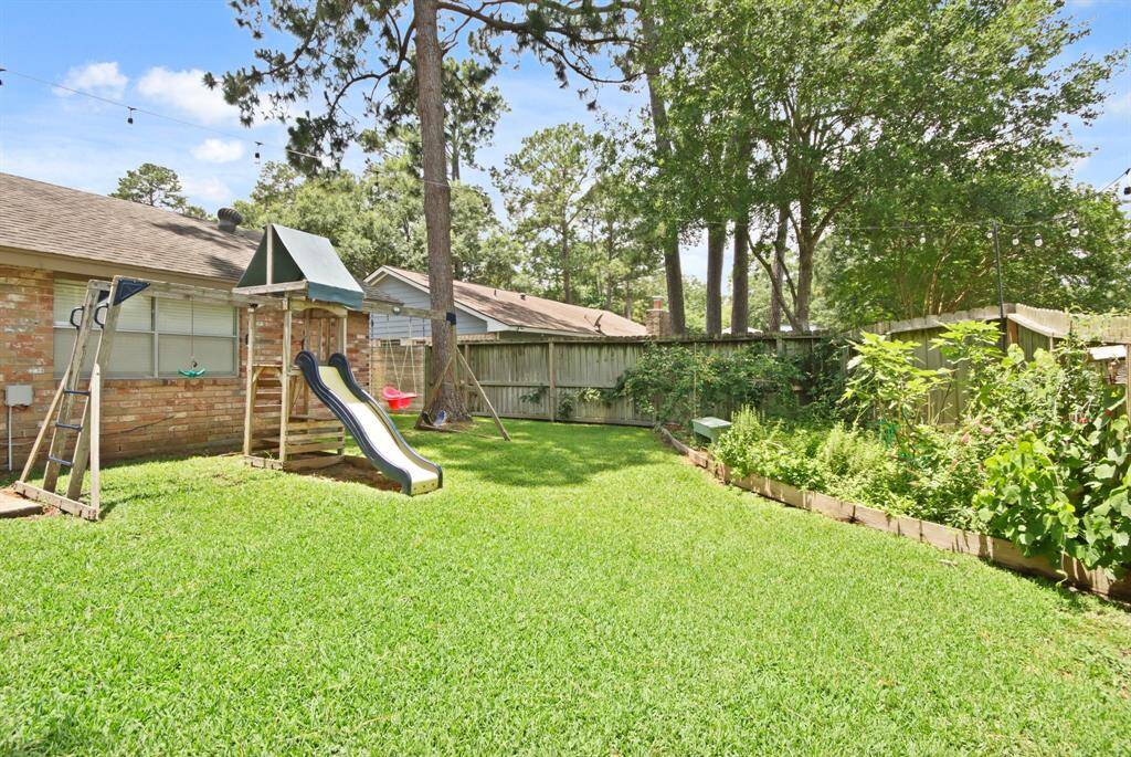 This backyard is definitely not lacking on green space! Featuring mature trees, lush lawn, and an a spot for gardening.