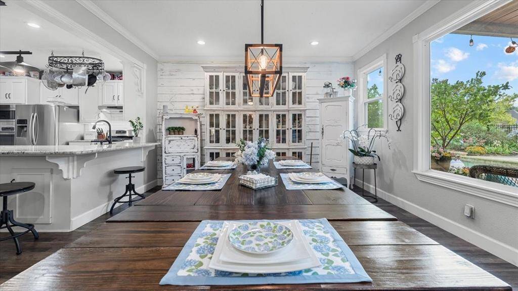 This inviting open-concept dining area sits adjacent to the kitchen. The space is brightened by the large windows.