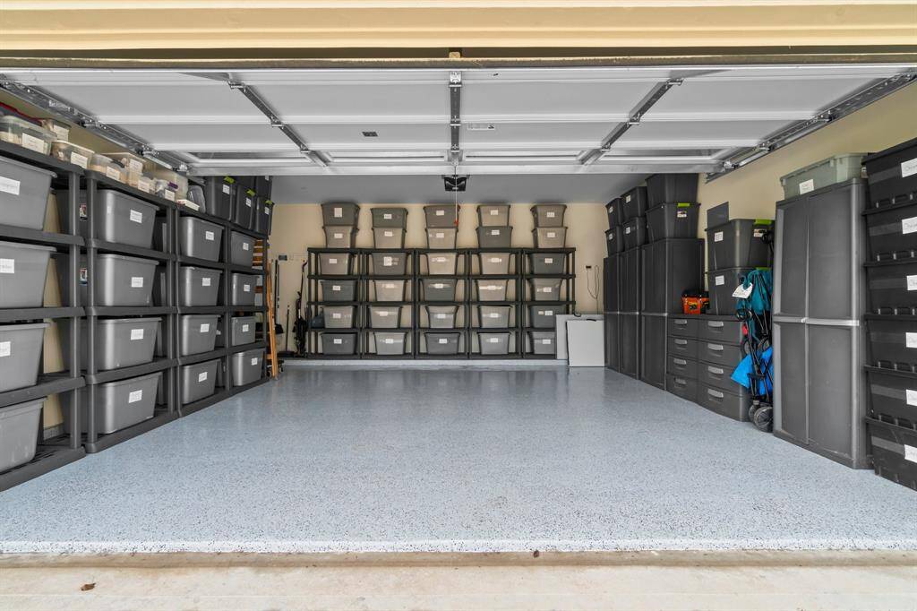 Spacious and well-organized garage with a clean, coated floor is deal for homeowners seeking ample storage space.