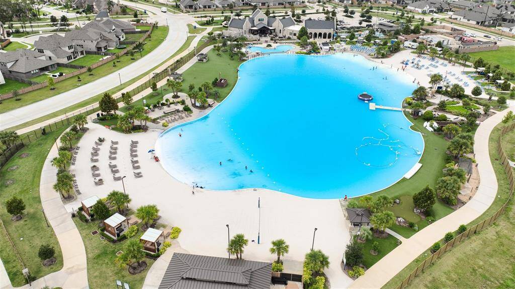Balmoral is a one of a kind residential community with a large, resort-style lagoon pool surrounded by lush greenery, lounge chairs, and walking paths. The area includes cabanas and is situated near modern homes, offering a luxurious and relaxing environment.