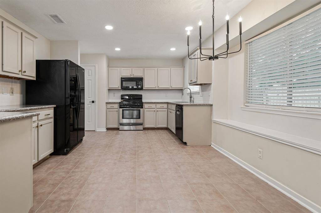 Beautiful kitchen featuring granite countertops, gas stove, and an abundance of natural light. Notice the large breakfast area near the window.