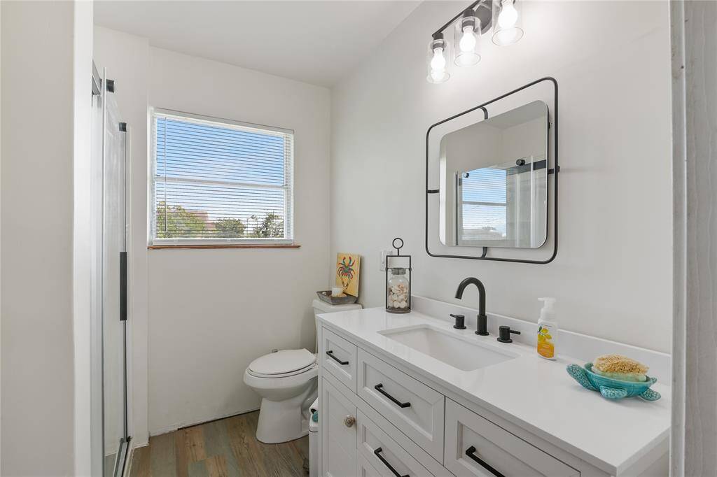 Bright second-floor bathroom featuring a modern sink and sleek shower.