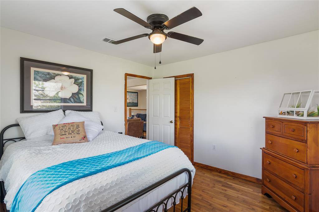 Spacious second-floor primary bedroom with hardwood floors and abundant natural light.