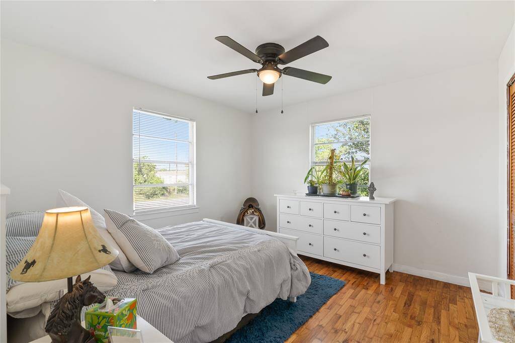 Bright and airy second-floor bedroom featuring fresh decor, ample natural light, and cozy hardwood floors—perfect for restful retreats.