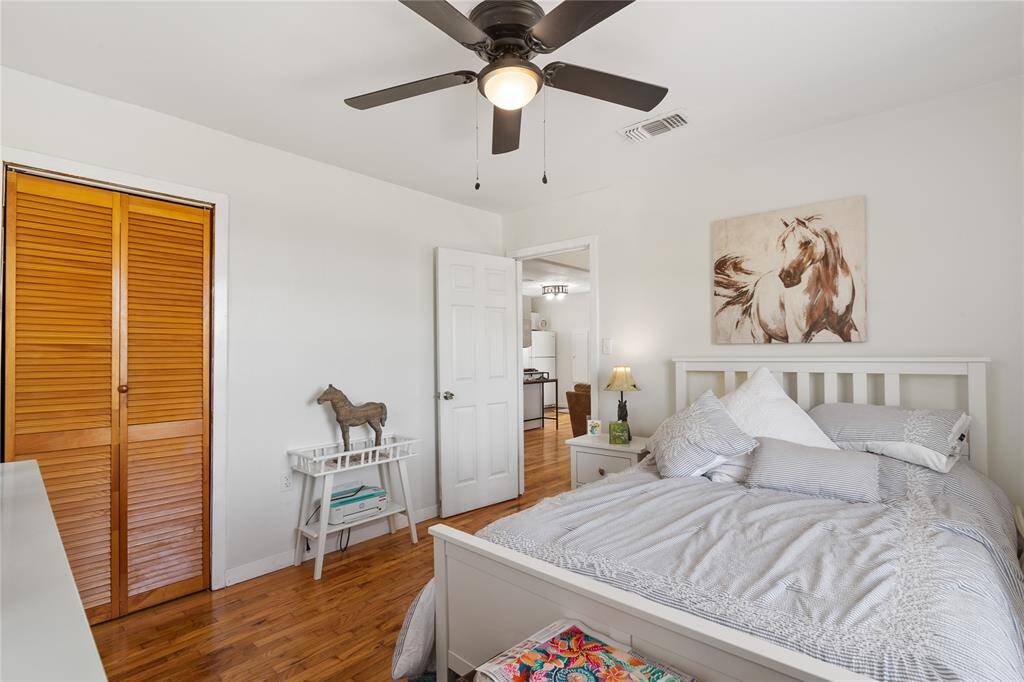 Spacious second-floor bedroom with natural light, hardwood floors, and a cozy ceiling fan. Perfect for relaxation and comfort.