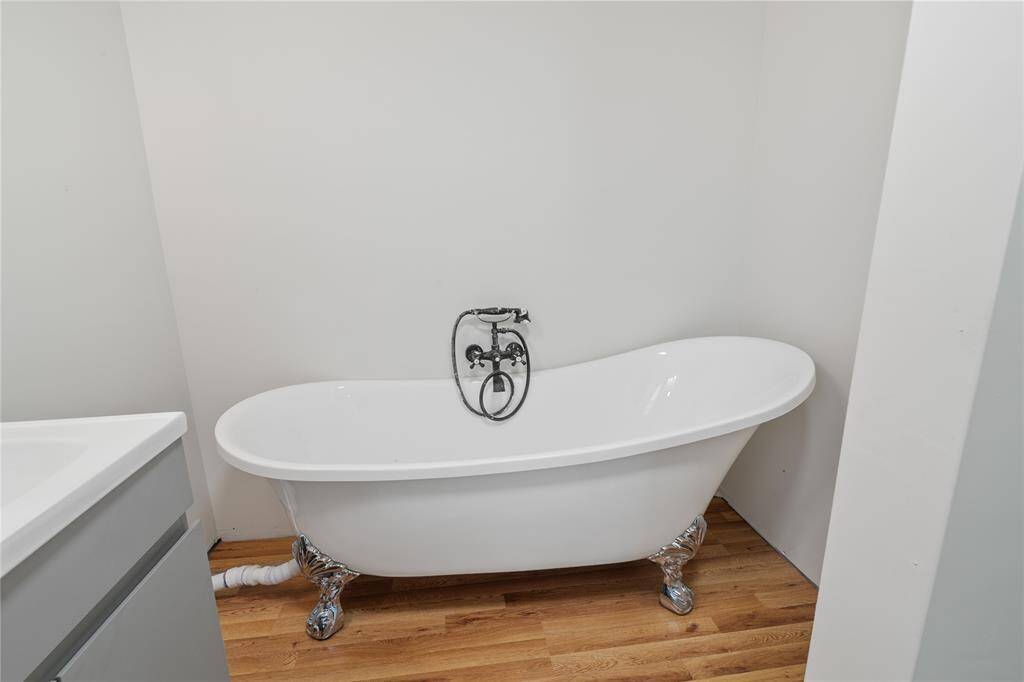 Elegant first-floor bathroom featuring a chic freestanding tub, modern fixtures, and abundant natural light.