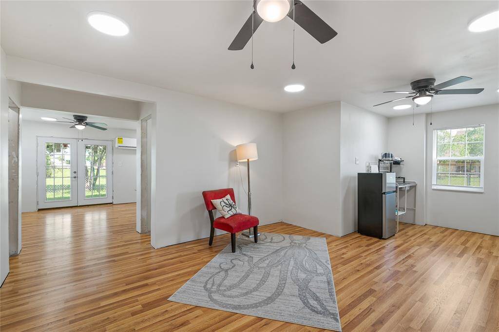 Spacious first-floor family room seamlessly connected to a kitchenette, with easy access to the second floor via an interior stairway.