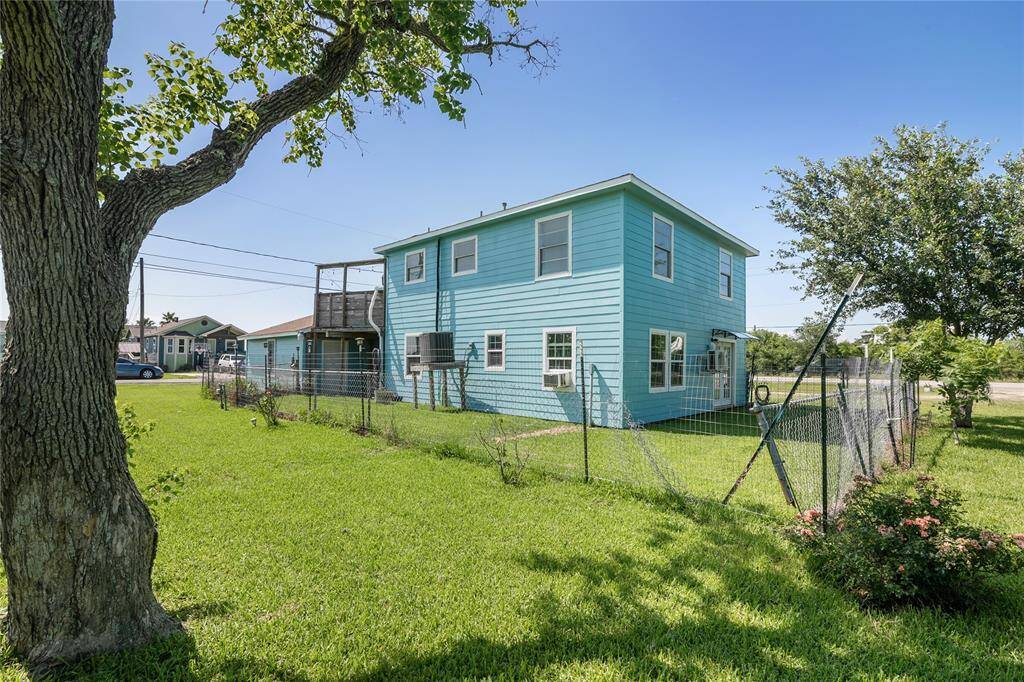 Spacious backyard with lush lawn, mature trees, and a charming two-story exterior. Perfect for outdoor relaxation and family gatherings.